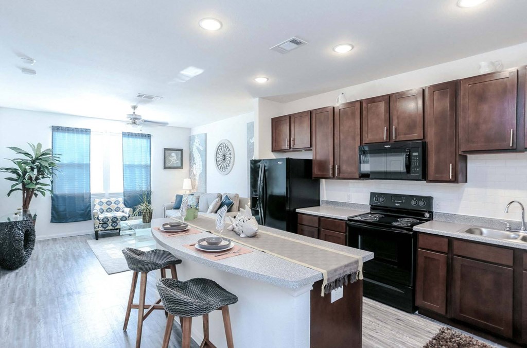 a kitchen and living room with wooden cabinets and a counter top