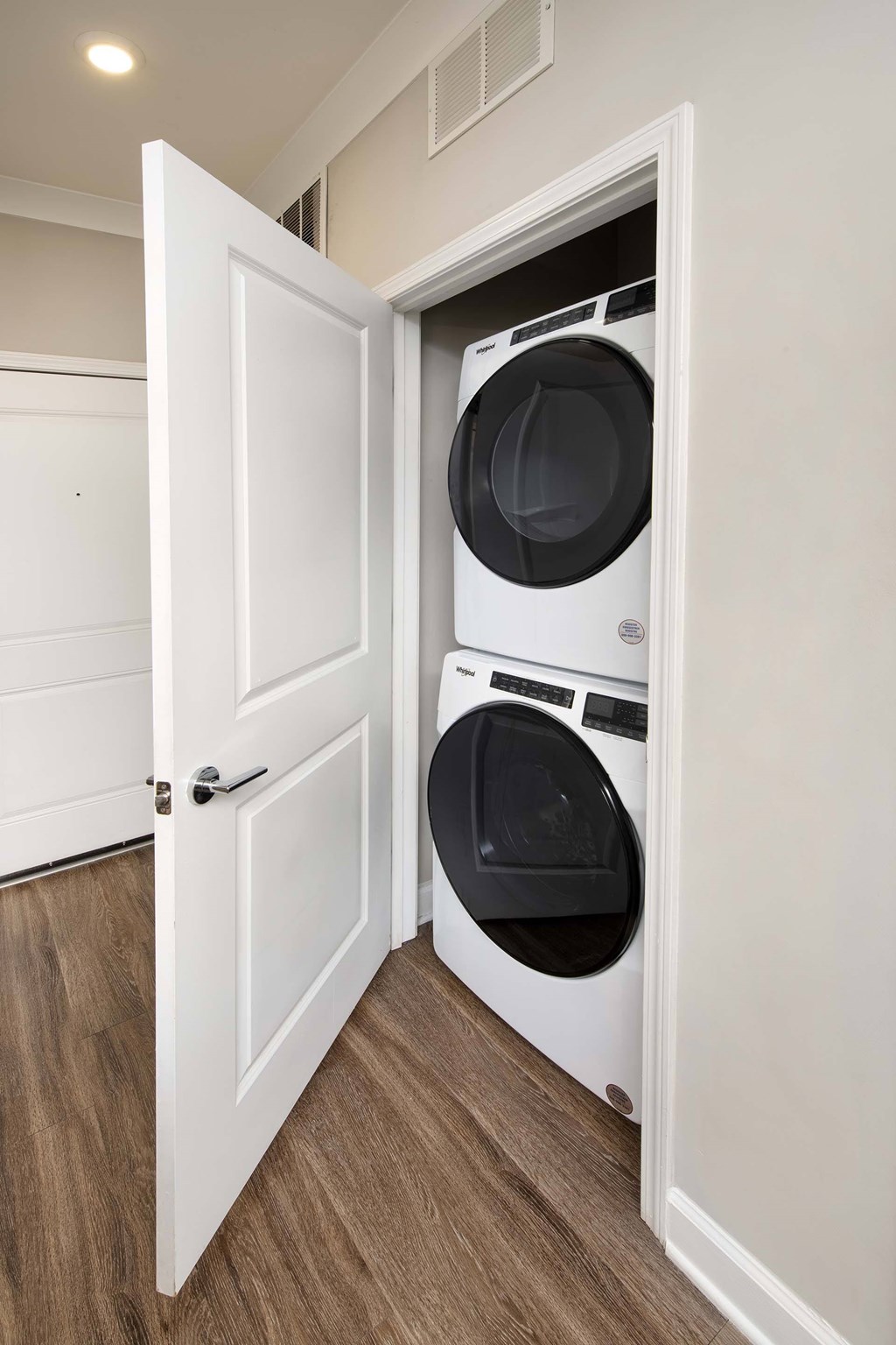 A white door is open to reveal a white washing machine.