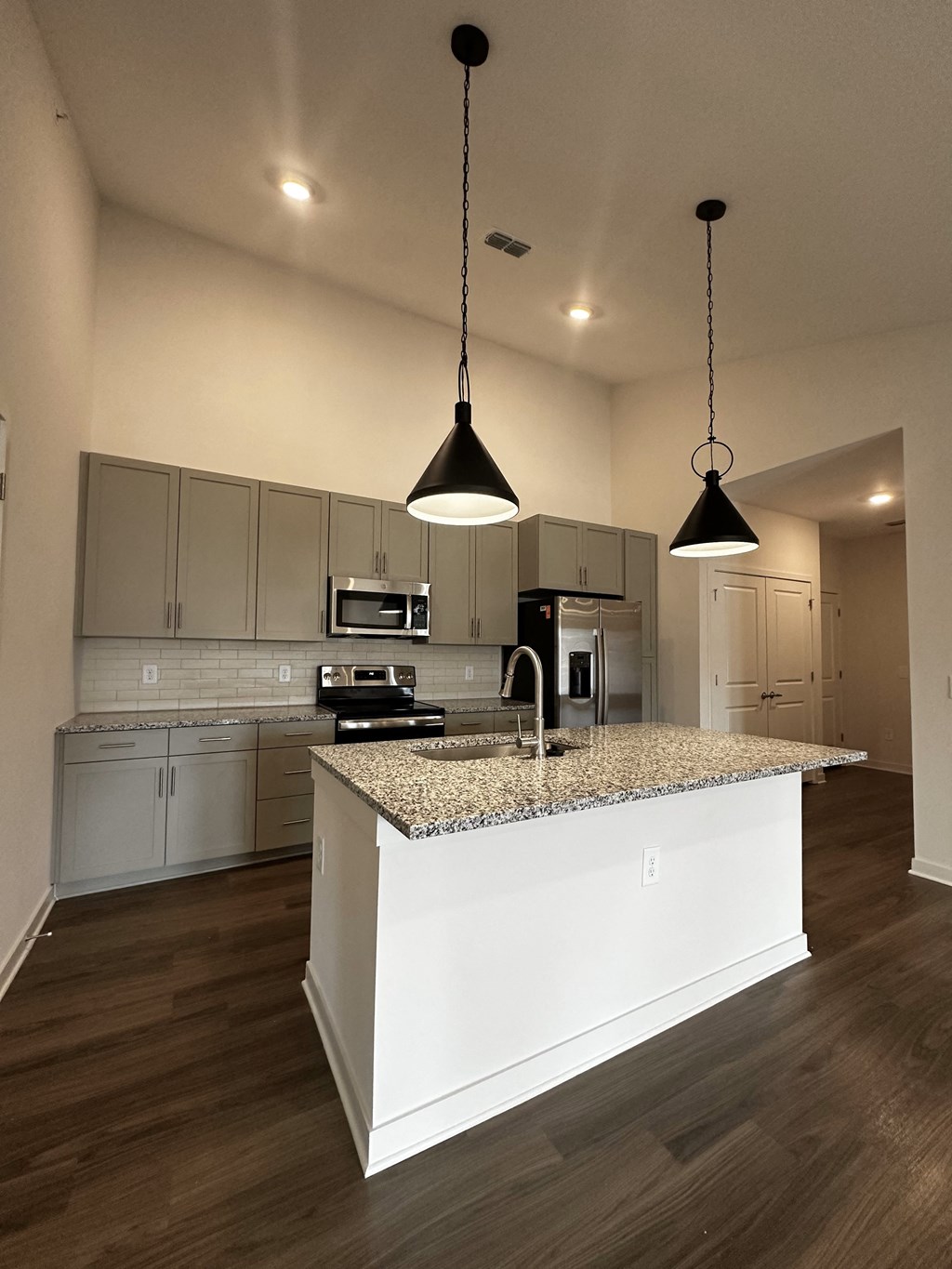 a kitchen with white cabinets and a granite counter top