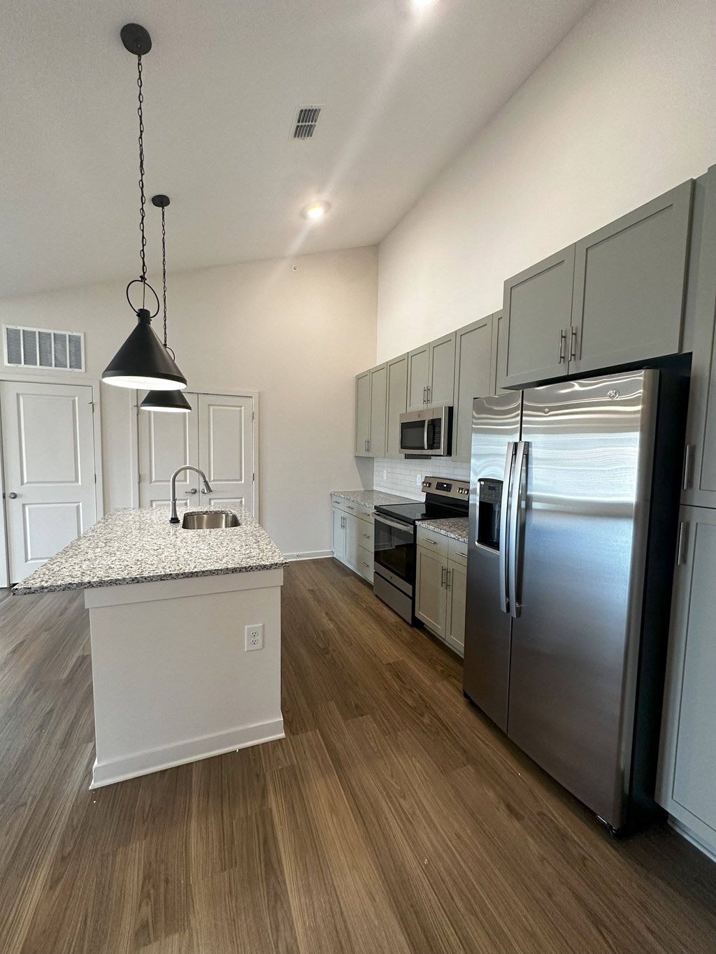 a kitchen with stainless steel appliances and a marble counter top