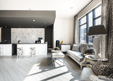 A modern living room with a white sofa and a leopard print chair.
