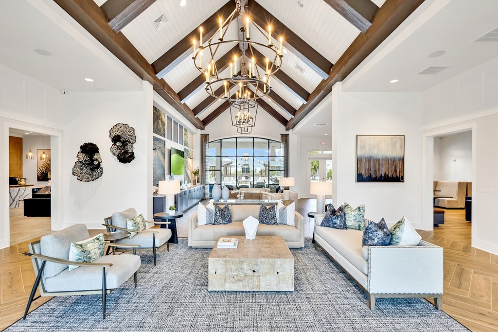 A large, well-lit living room with a variety of seating options and a chandelier.