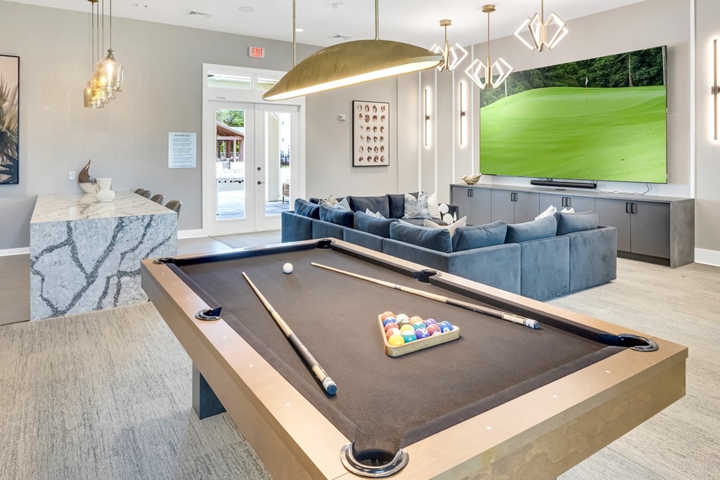 A pool table with a green cloth and a set of pool balls in the middle.