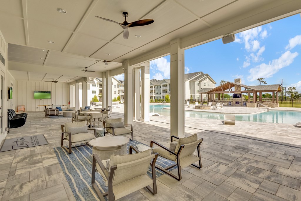 A patio with a pool and chairs.