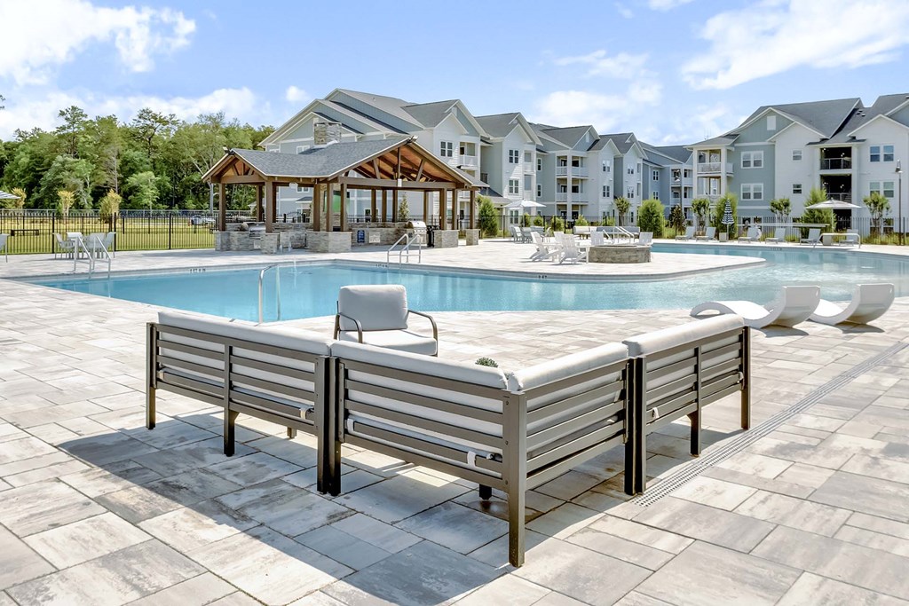 A pool with a bench in front of a building.