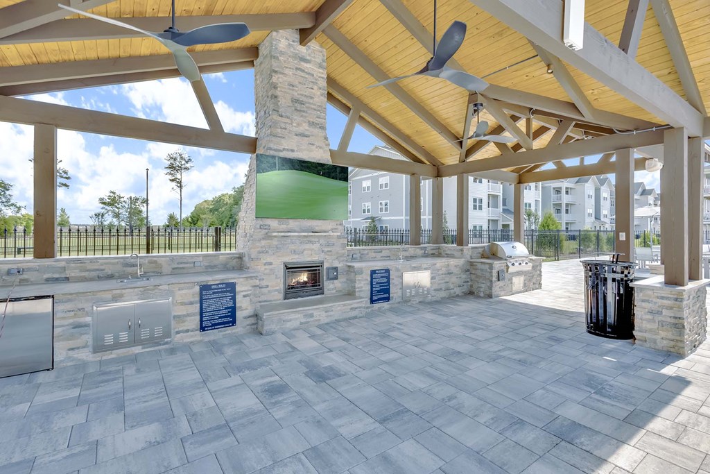 A patio with a fireplace and a trash can.