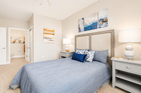 A bedroom with a bed, nightstand, and two lamps.