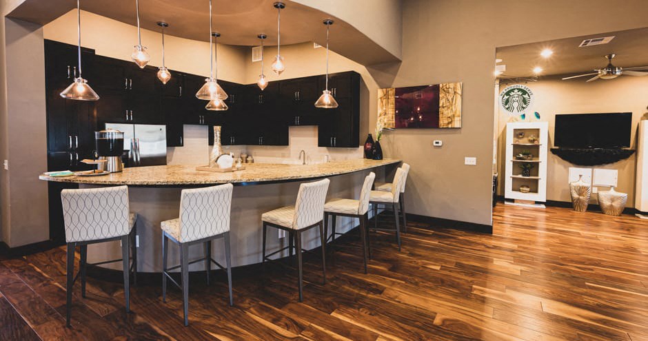 a kitchen and dining room with a bar and chairs