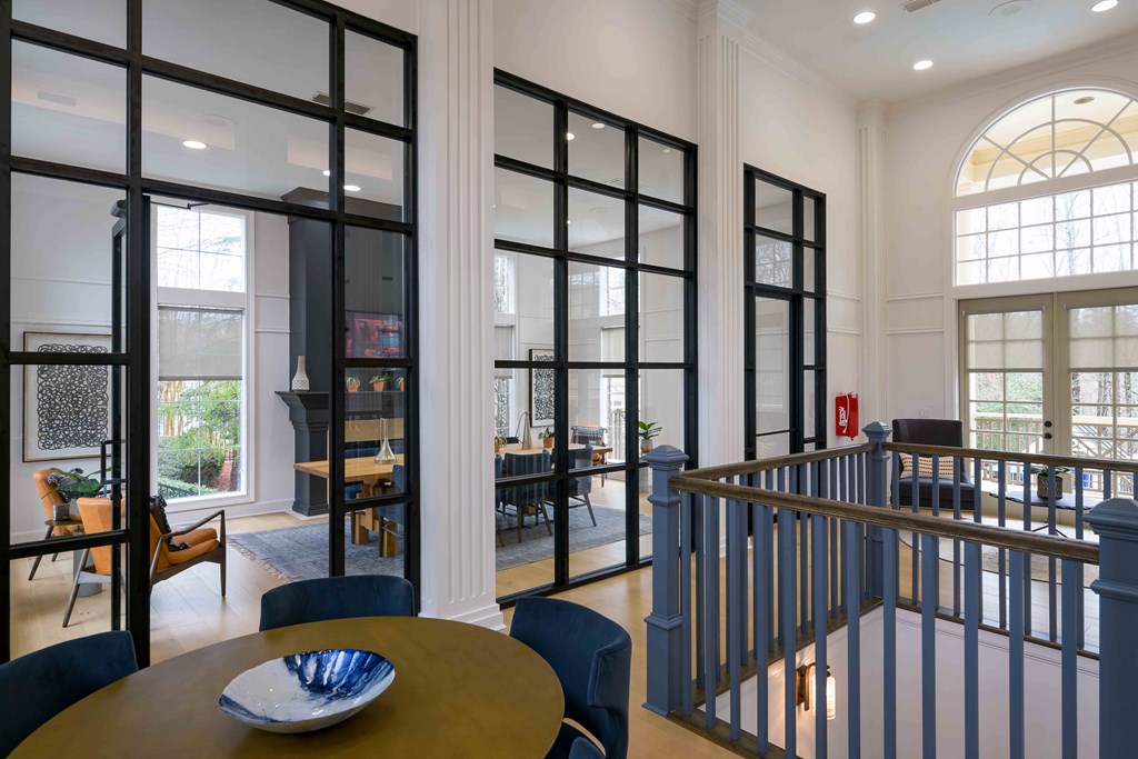 a dining area with a table and chairs and large windows