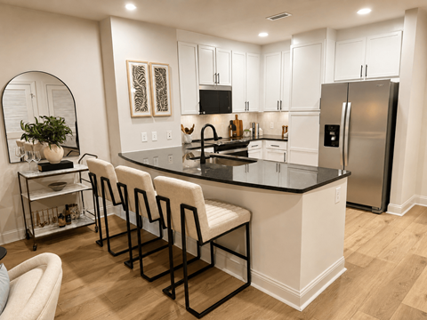 A kitchen with white cabinets and a black countertop.