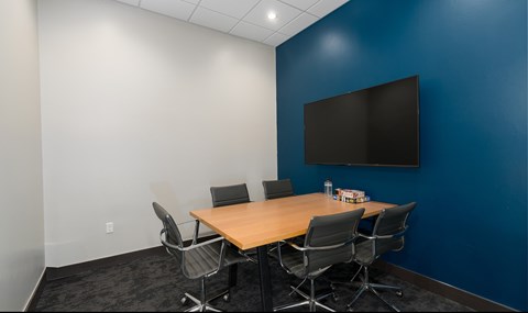 A conference room with a large table and chairs.