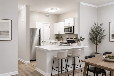 A modern kitchen with white cabinets and a wooden table.