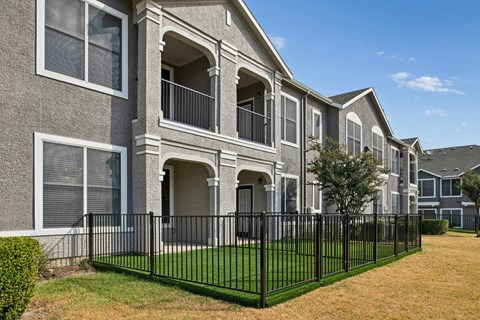 A row of houses with black fences in front.