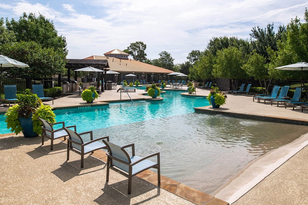 a swimming pool with chairs and umbrellas