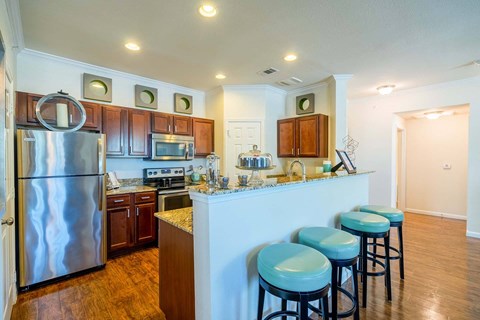 a kitchen with a breakfast bar and stainless steel appliances