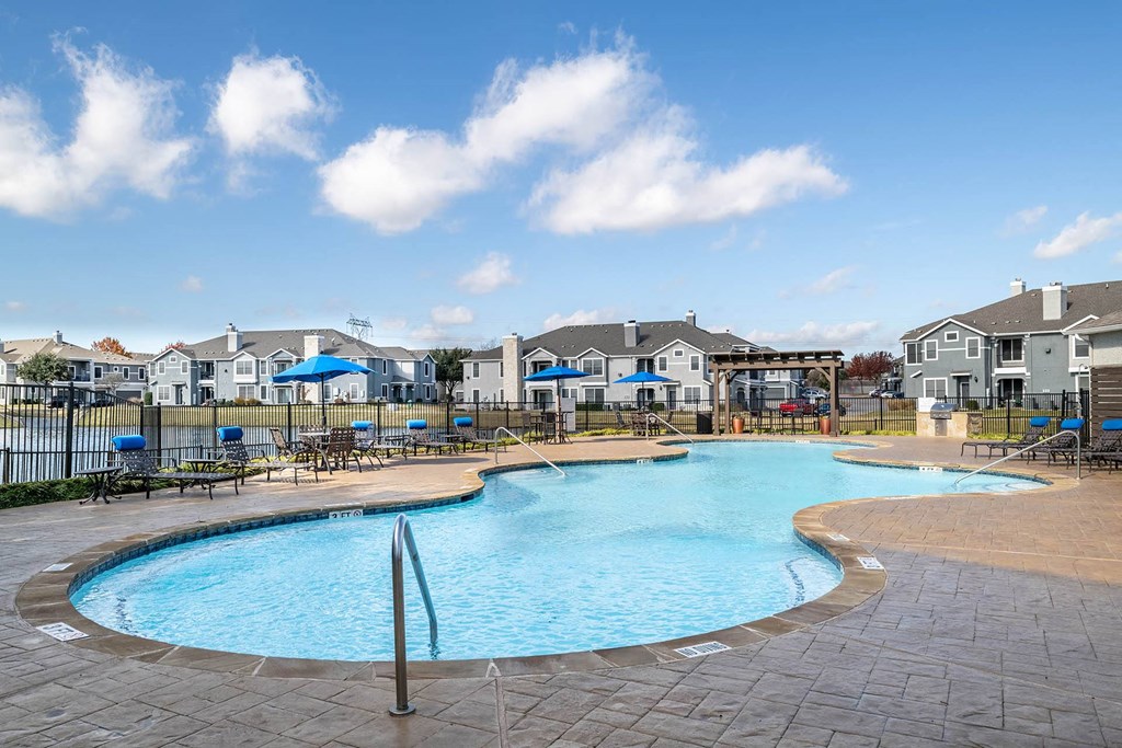 a large swimming pool with apartments in the background  at Orion Prosper, Prosper