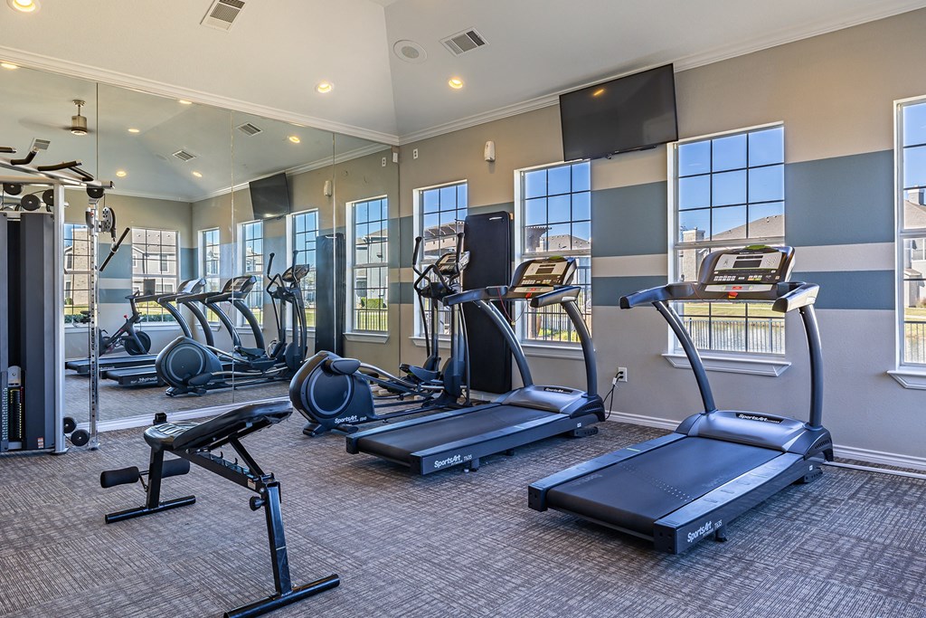 a gym with cardio equipment and windows  at Orion Prosper, Texas