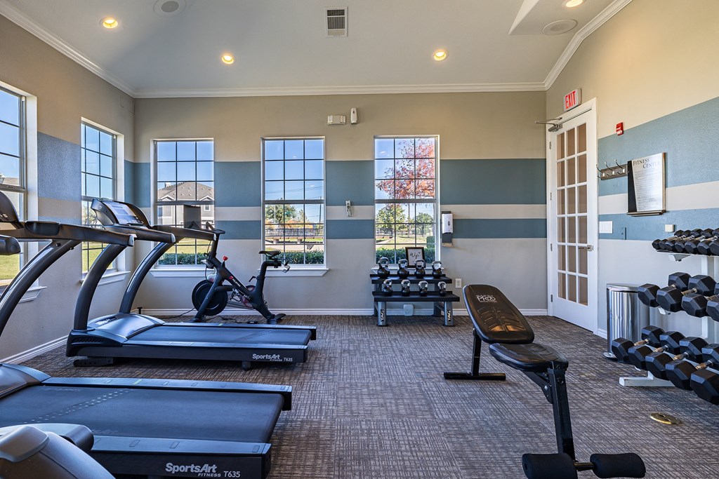 a gym with treadmills and other exercise equipment and windows  at Orion Prosper, Prosper, Texas