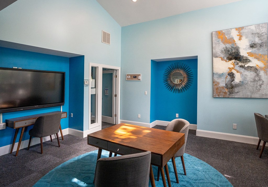 a living room with a tv and a table and chairs