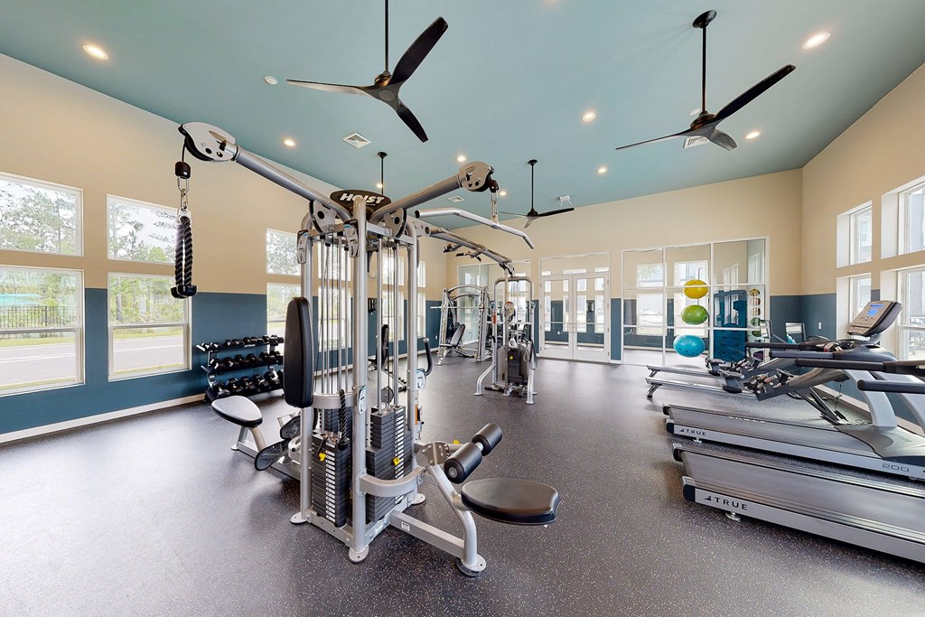 a gym with weights and cardio equipment at the estates apartments
