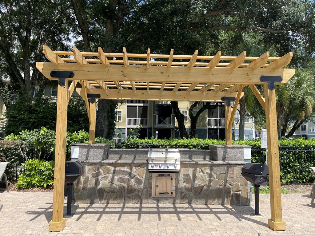 a pergola with a grill in front of a building