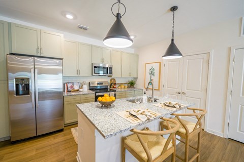 a kitchen with a marble counter top and a stainless steel refrigerator