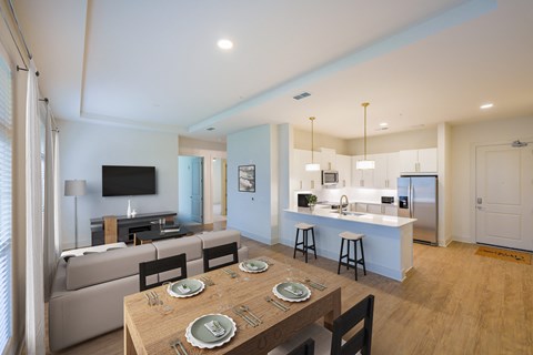 A modern dining room with a wooden table set for four.