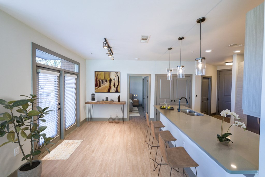 A kitchen with a long counter and bar stools.