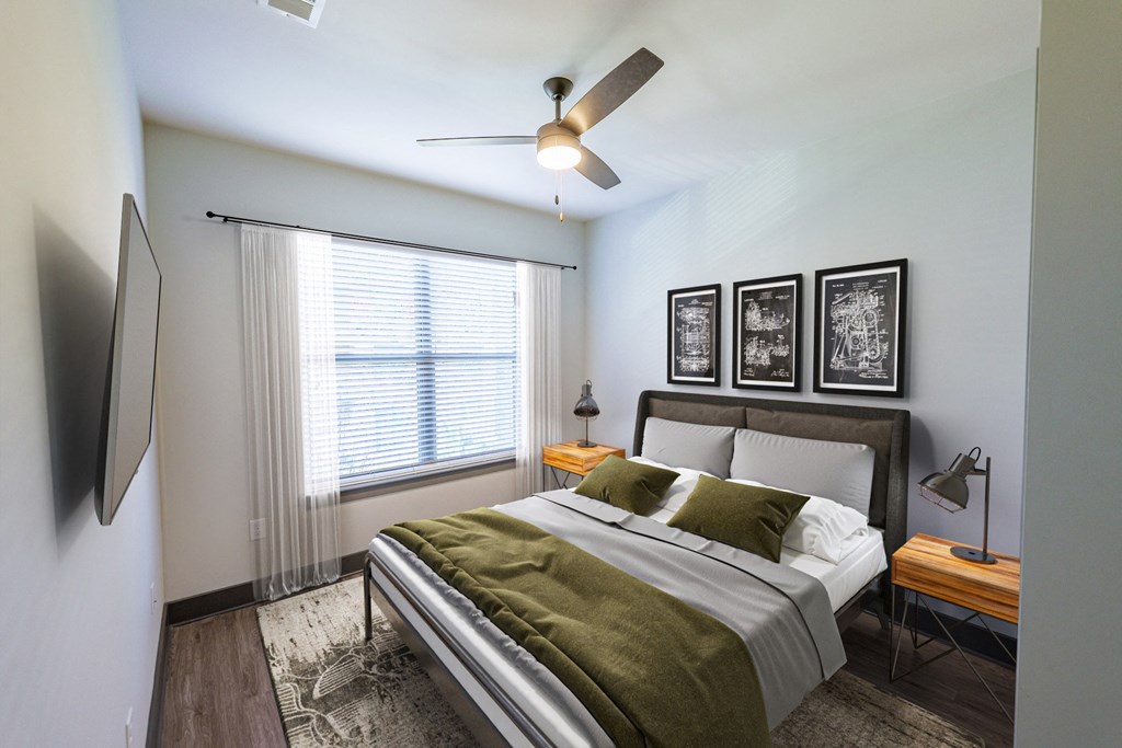 A bedroom with a bed, a ceiling fan, and a television.