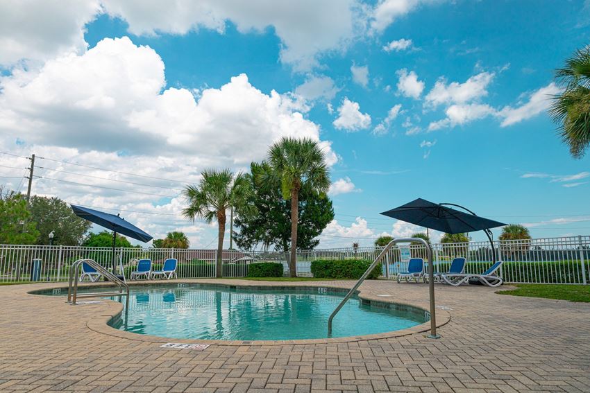 a resort style pool with chaise lounge chairs and umbrellas - Photo Gallery
