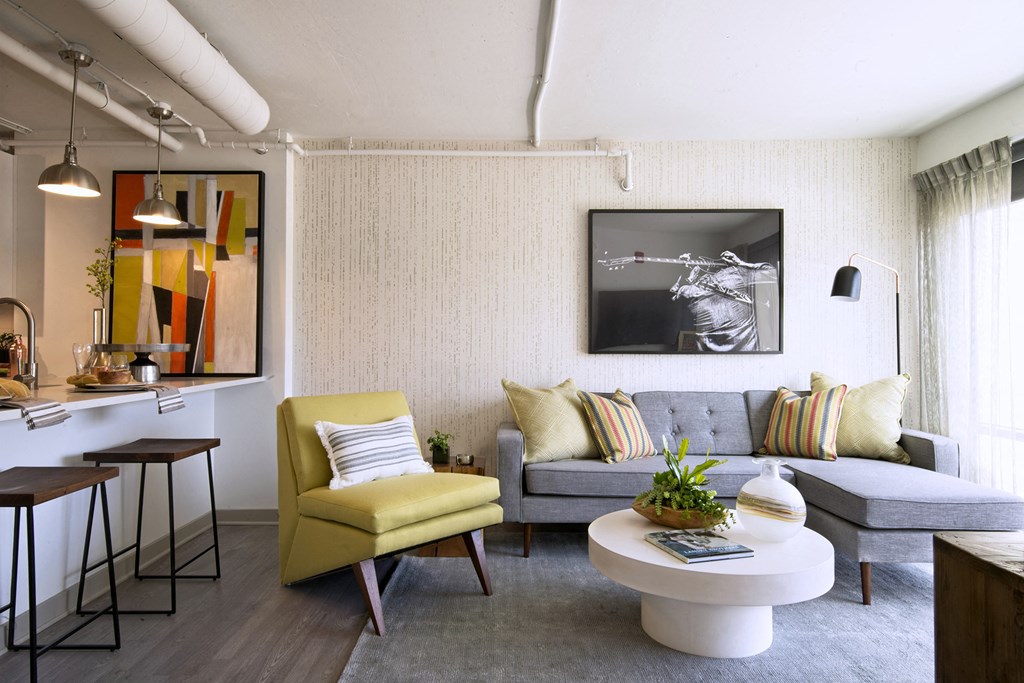 a living room with a gray couch and a yellow chair