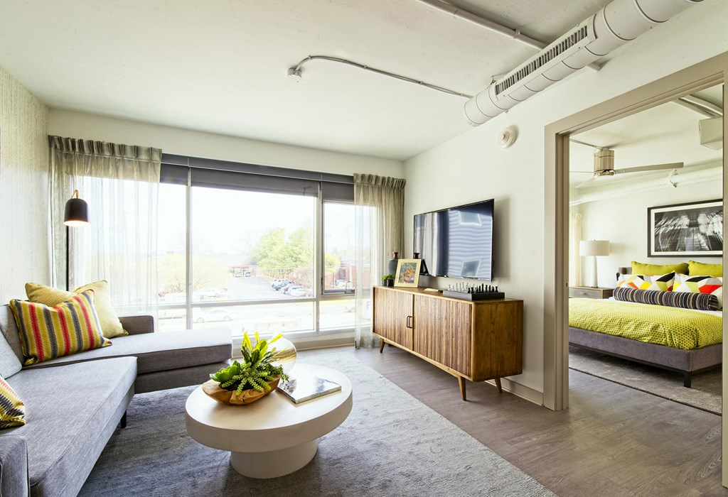 a living room with a couch and a coffee table    and a bedroom