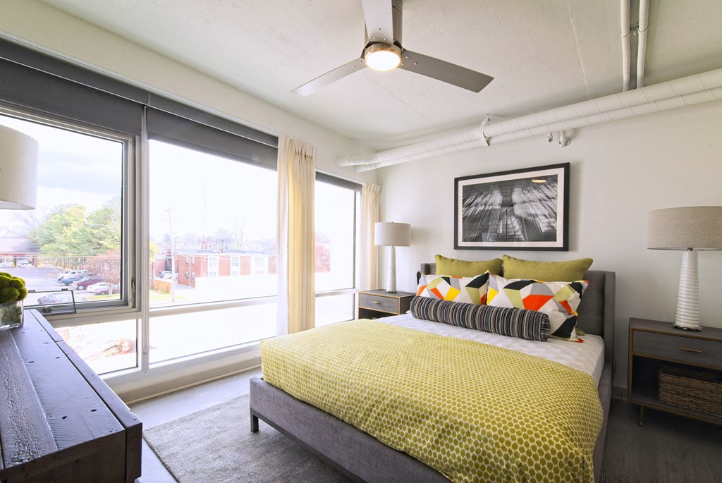 a bedroom with a bed and a large window