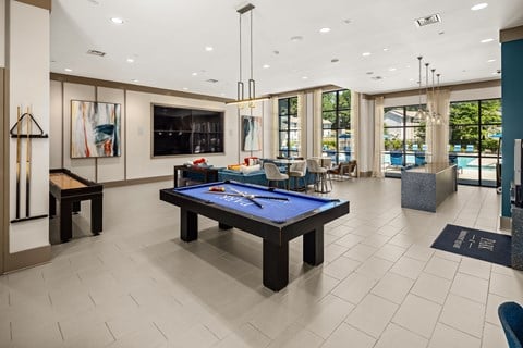 A billiard table is in the middle of a room with a pool table and a bar.