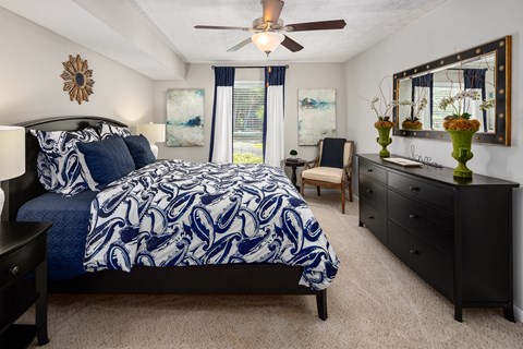 A bedroom with a large bed and a ceiling fan.