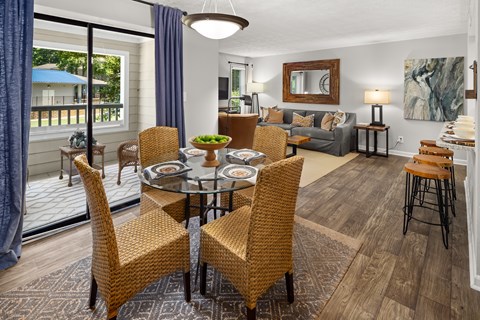 A dining room with a glass table surrounded by chairs.