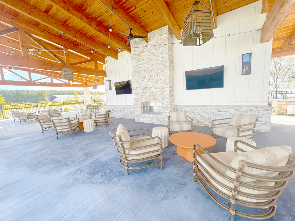 A patio with a stone fireplace and a TV mounted on the wall.
