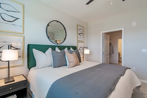 1-Bedroom Apartments in Madison, AL - Paxton Place - Spacious Bedroom with Plush Carpet, Bed, Nightstands with Lamps, Mirror, and Spacious Closet.
