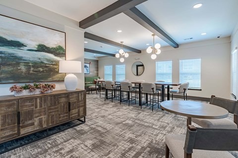 a dining room with tables and chairs and a large painting on the wall