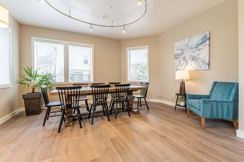 A dining room with a large table and chairs.