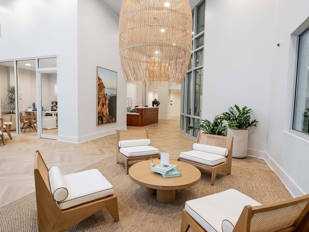A living room with a large wooden chair and a round wooden table.