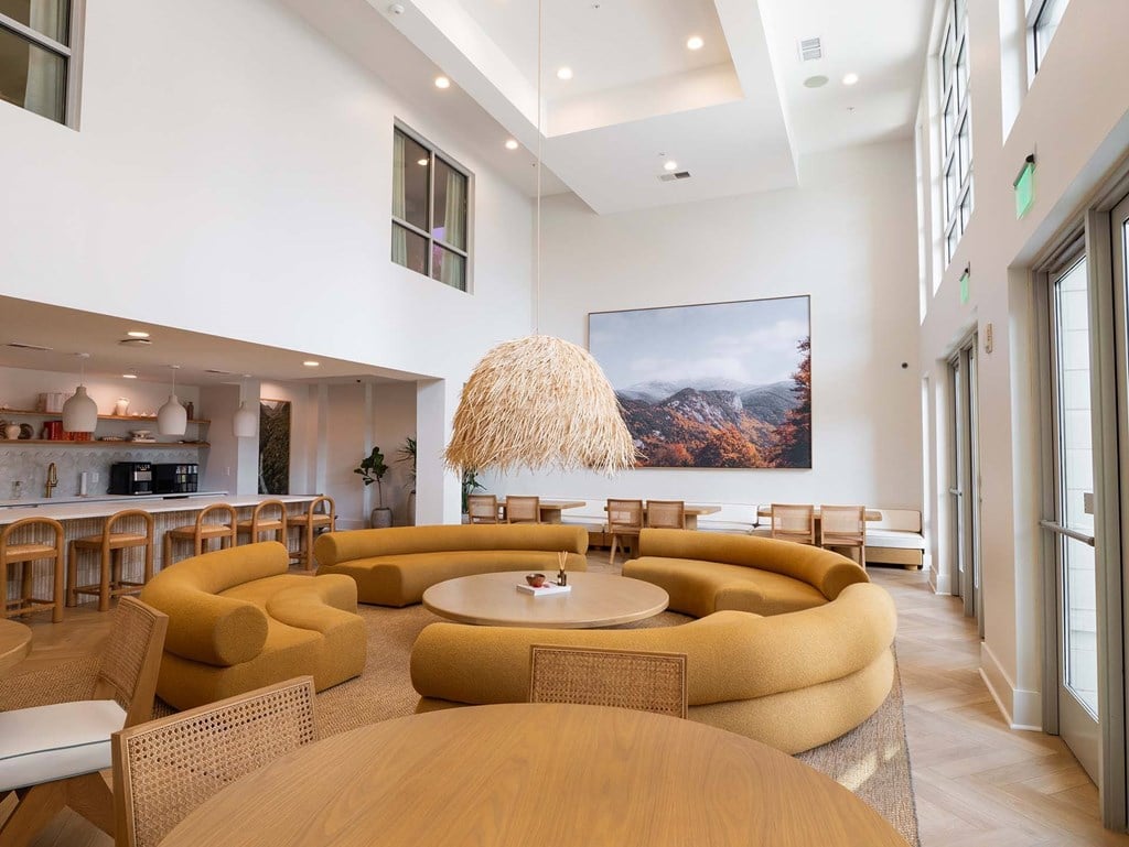 A modern living room with a large painting on the wall and a unique yellow sofa.