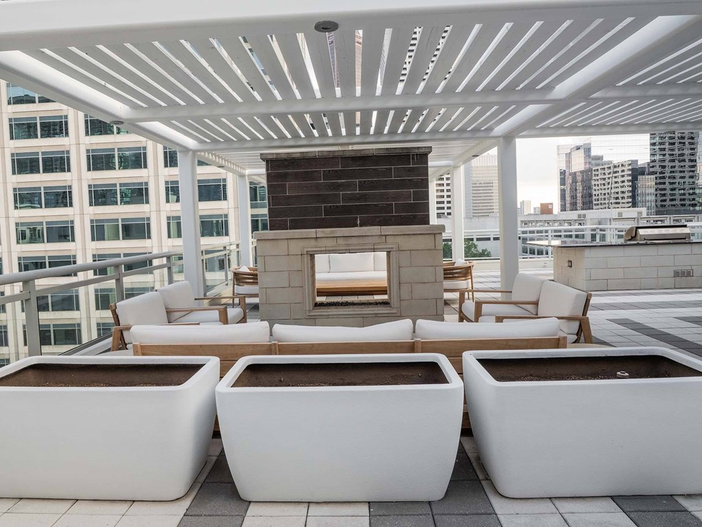 A patio with a white pergola and two hot tubs.