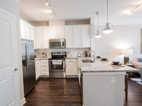 A kitchen with white cabinets and a granite countertop.