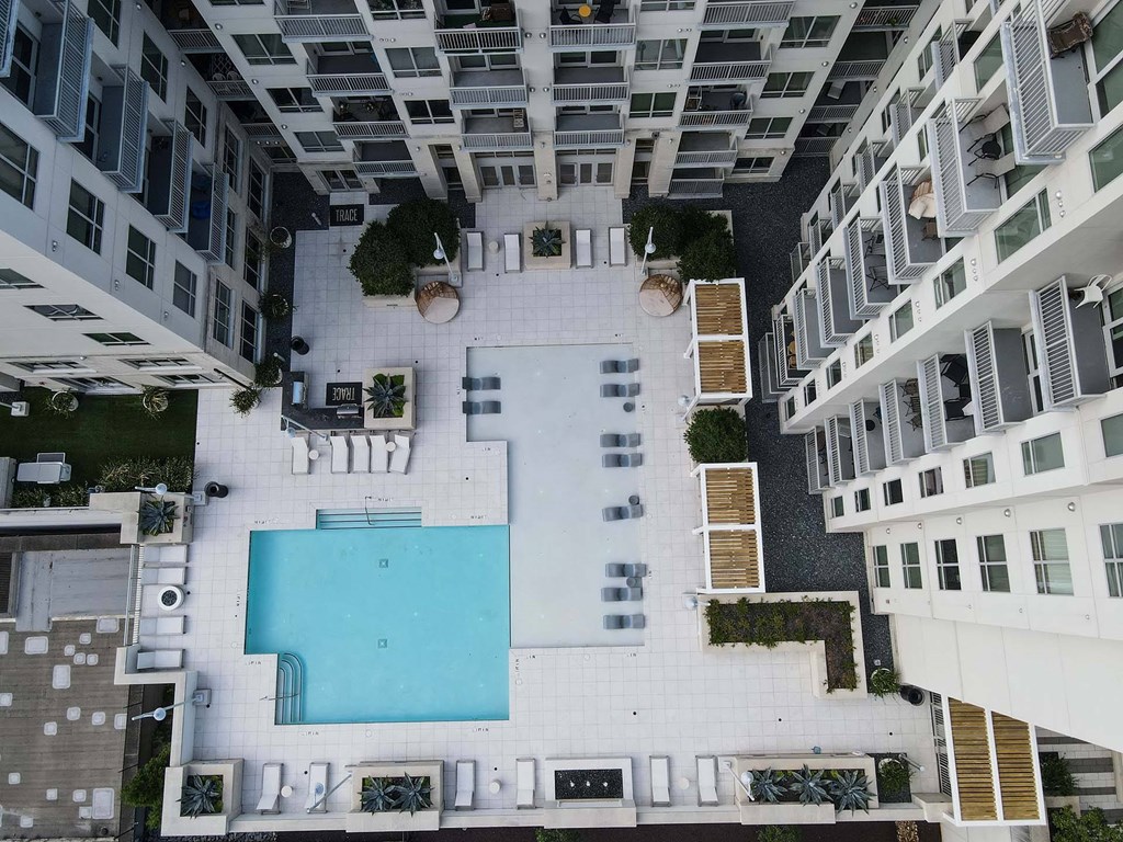 A swimming pool is surrounded by balconies in a residential building.