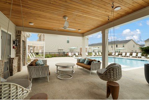 A patio with a pool and a ceiling fan.