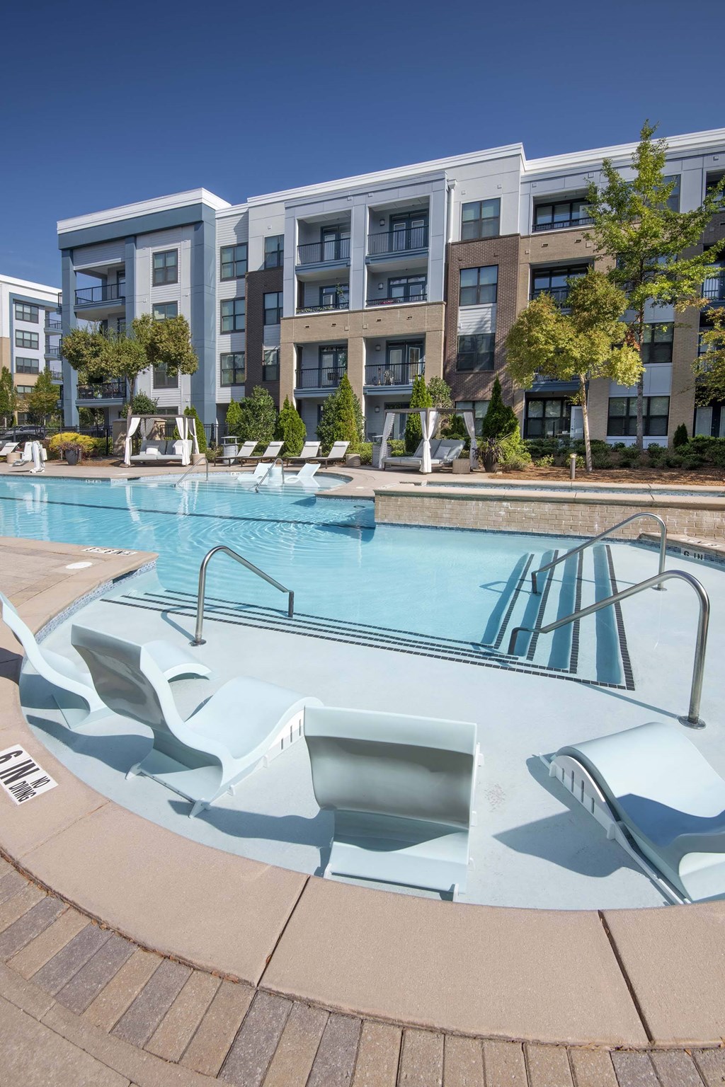 A swimming pool with a slide in front of apartment buildings.