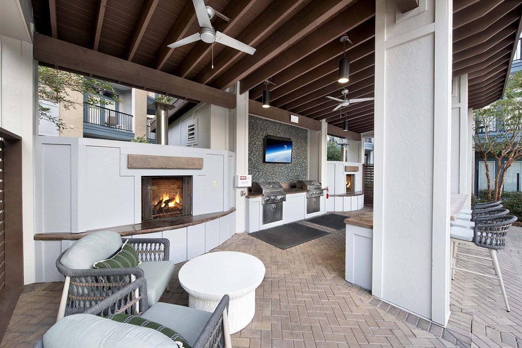 A patio with a fireplace and chairs.
