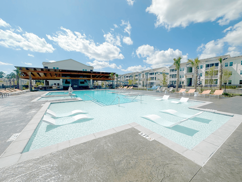 A large swimming pool with a building in the background.