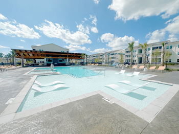 A large swimming pool with a building in the background.